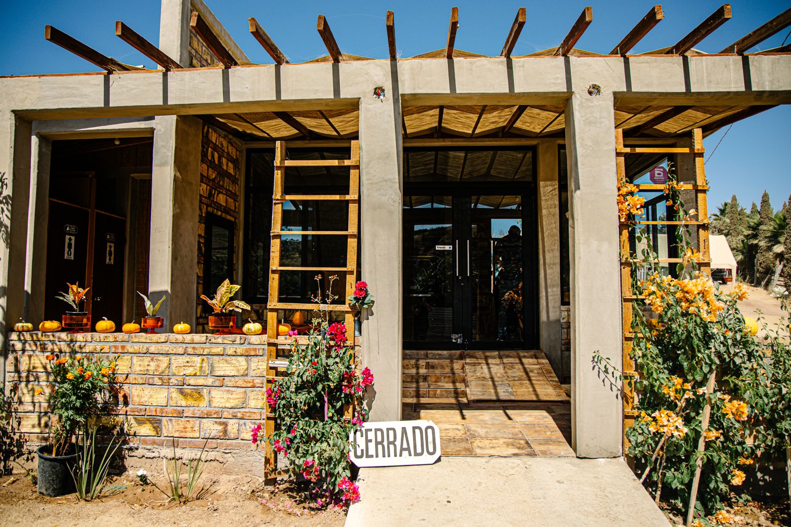 Entrada principal de María's Sabor del Campo con pérgola de madera y flores