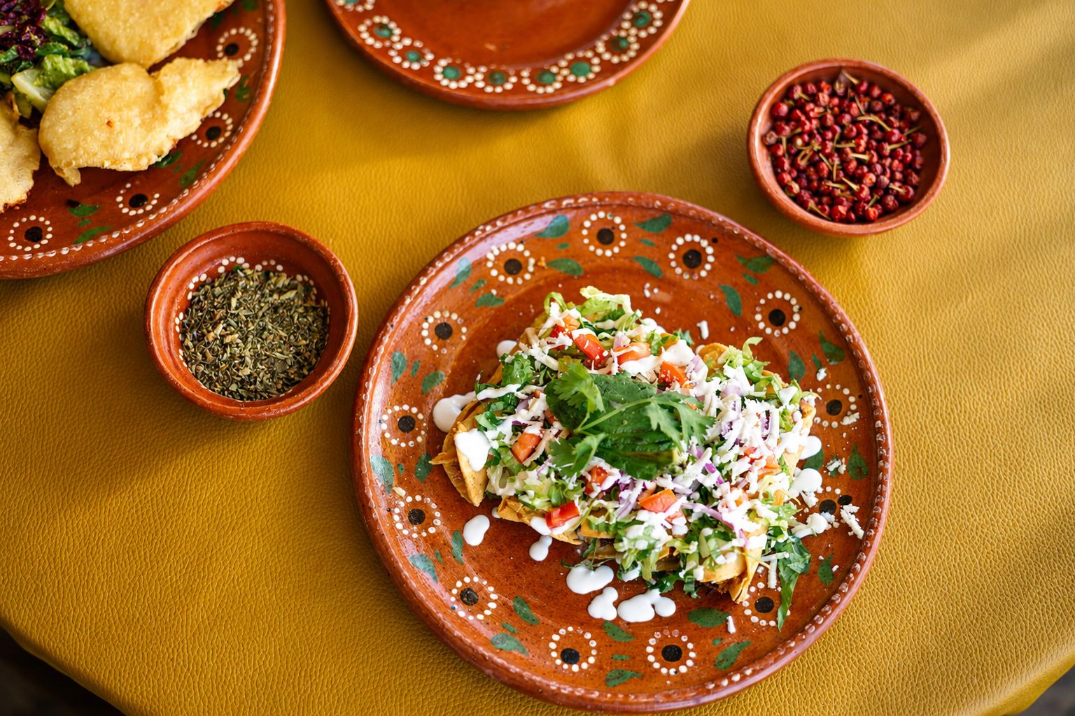 Flautas servidas en plato de barro con orégano y chiles