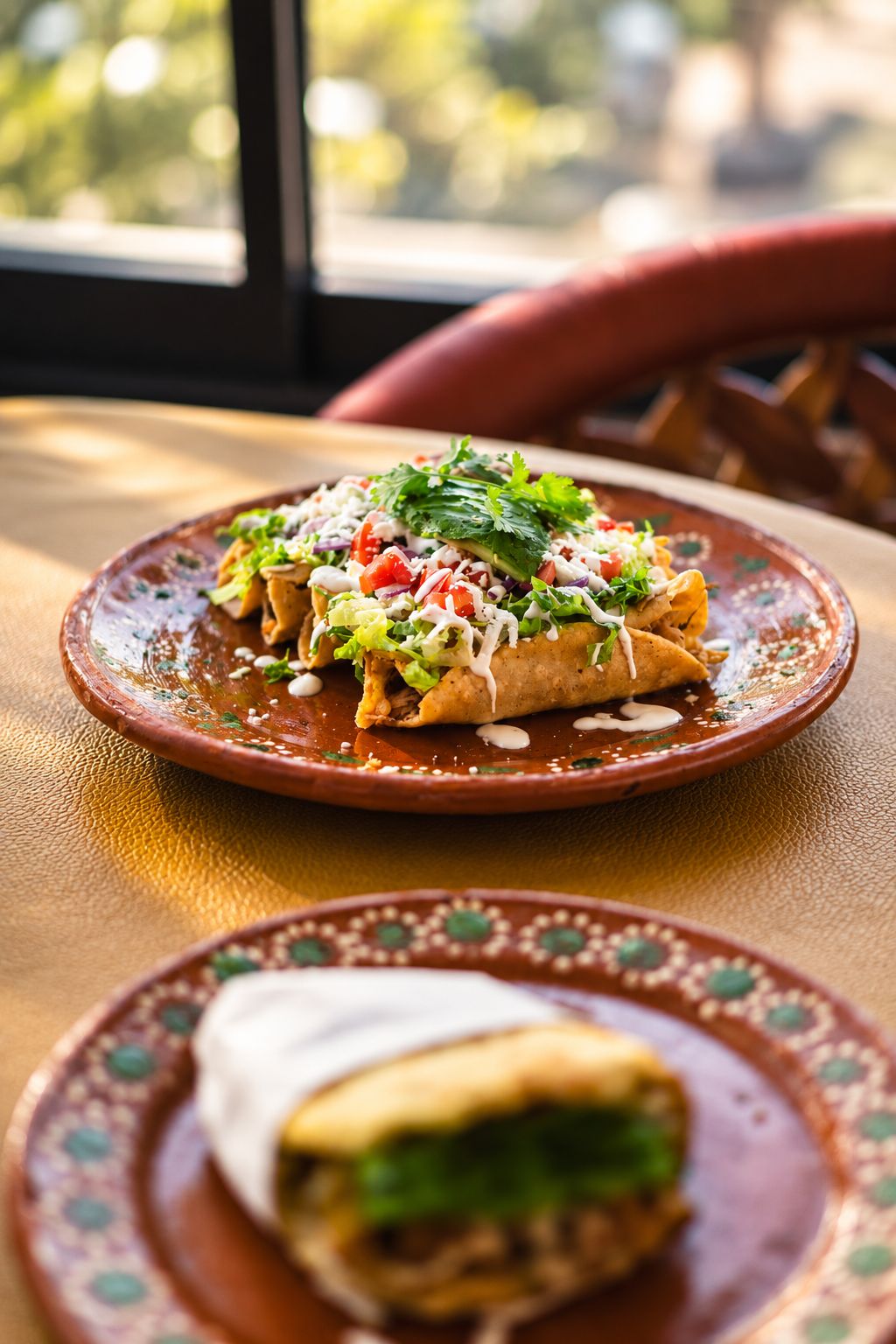 Flautas de carne doradas coronadas con lechuga, crema y queso